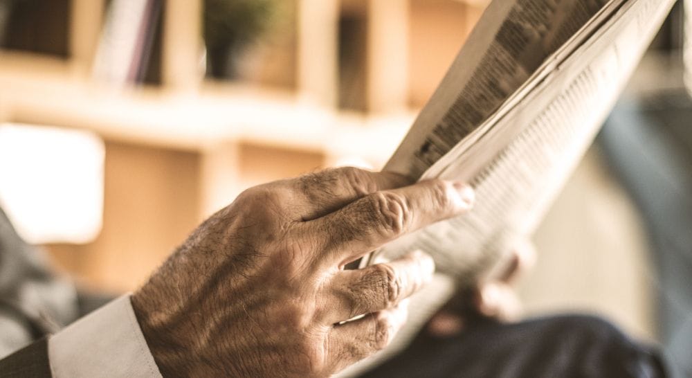 Zeitungsleser informiert sich über Geld Invest Anlagemöglichkeit Diamant