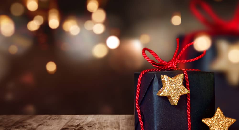 Wertvolles Weihnachtsgeschenk mit funkelnden Lichtern im Hintergrund